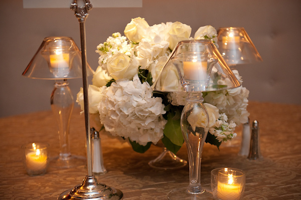 reception tabletop decor - white and ivory pomander and glass lamp shaped candle holders with golden yellow candles - holding yellow candles -photo by Houston based wedding photographer Adam Nyholt